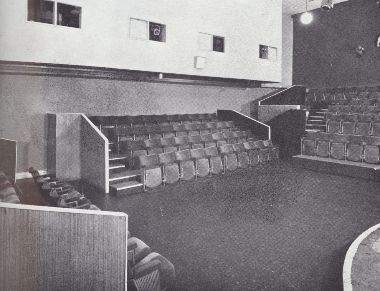 The interior of the Close Theatre. A small stage surrounded on three sides by four rows of seats.