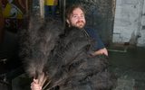 Backstage at the Citizens Theatre. A man in a wheelchair is holding a very big feathered fan and smiling at the camera.