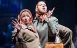 Production image from The Gorbals Vampire. Two woman in 1950s style clothing and head scarves pose dramatically. One is miming smoking a cigarette.
