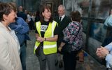 Members of the public standing in the Citizens Theatre's historic paint frame. A woman in a Citizens Theatre t-shirt and high vis vest is telling them about the space.