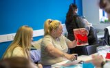 A woman shows off a print she made during a Tomorrow's Women session.