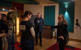 A group of people standing in a recording studio. One woman appears to be showing the space to the others.