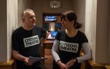 Two Citizens Theatre Participate staff members speaking to each other. Both are wearing Citizens Theatre t-shirts and the recording studio can be seen in the background.