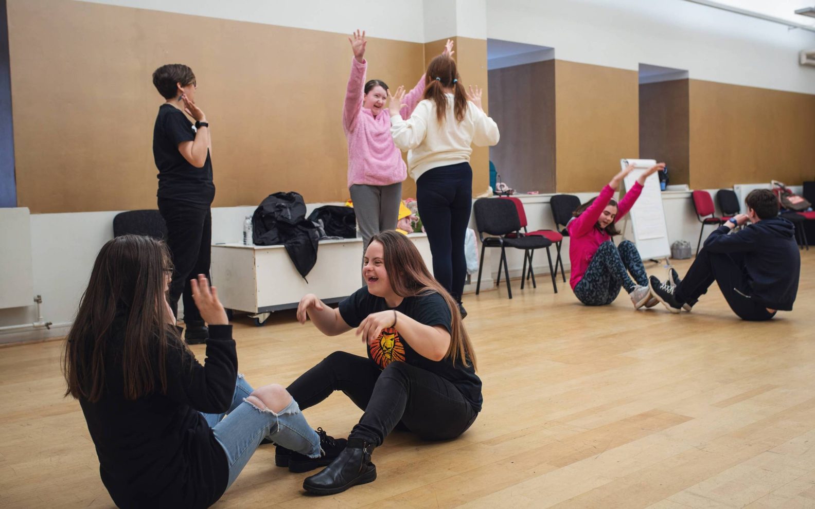 A group of learning disabled young people playing a drama game.