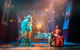 Beauty and the Beast on stage, they are sitting around a dining table.