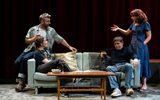 Four people sat around a sofa talking.