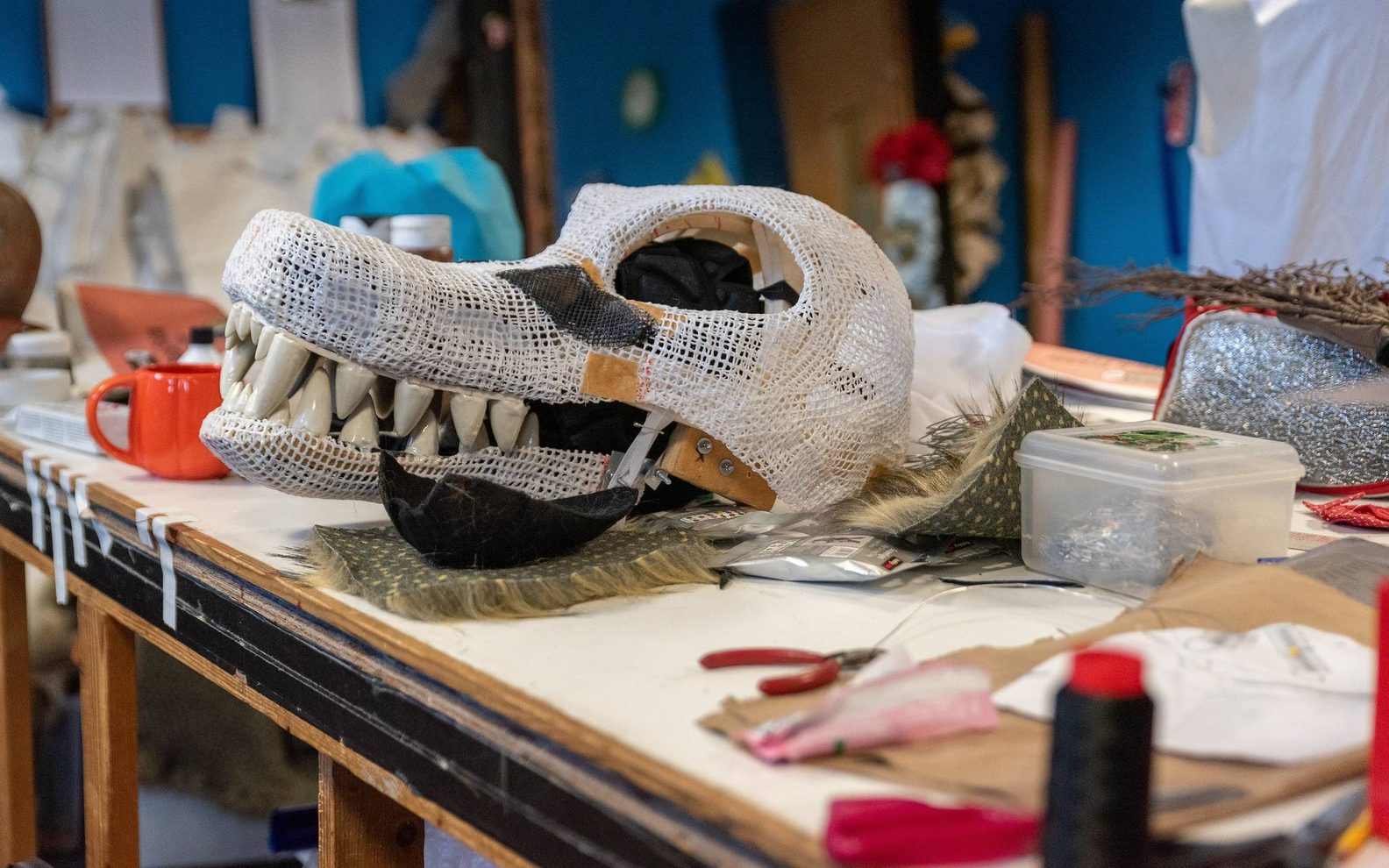 A workshop bench with a mask that's been half made.