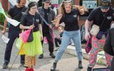 A group of people with Citizens Theatre t-shirts dancing with headphones on.