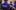 A man standing with his back to the camera. On the back of his purple t-shirt, it reads Citizens Theatre.