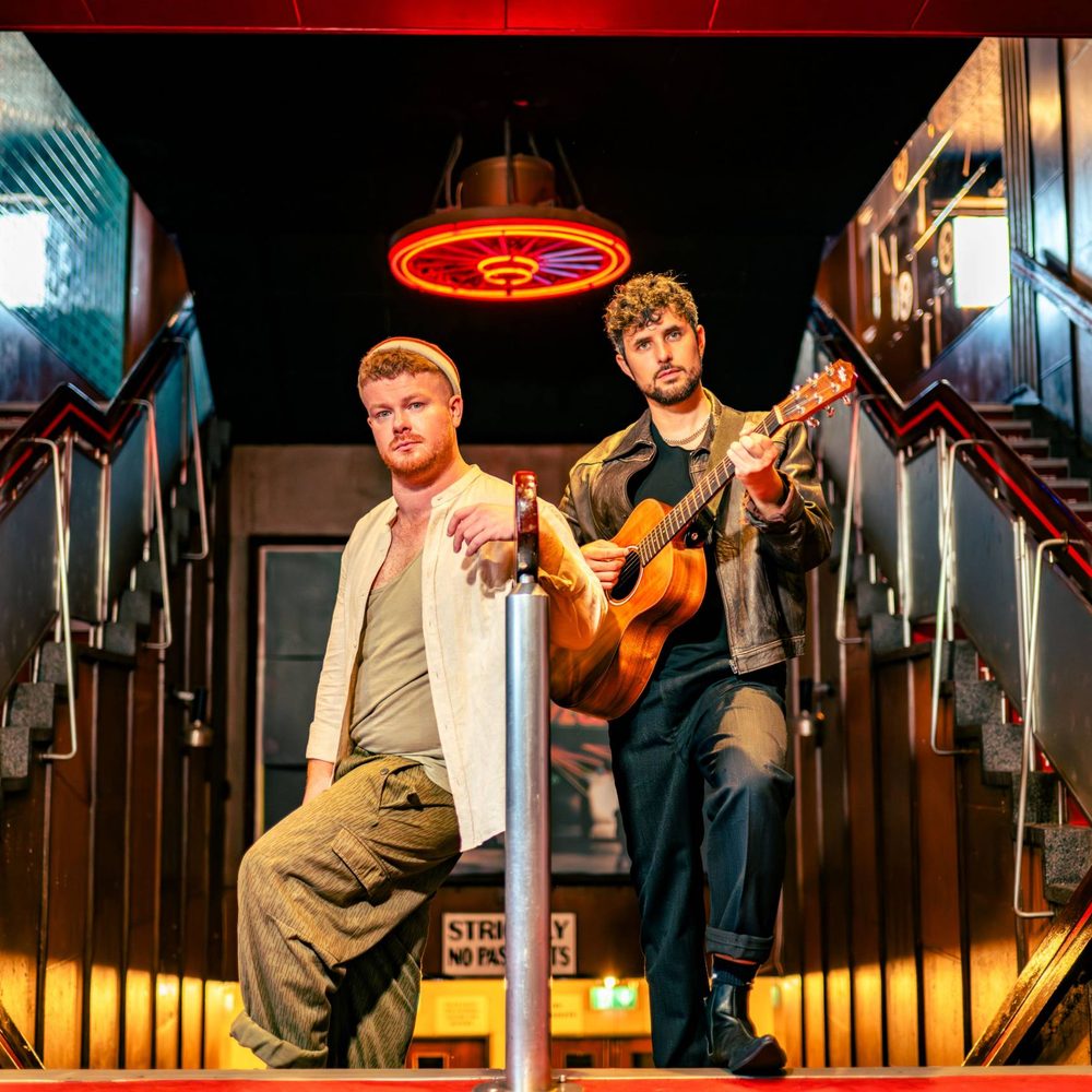 Jamie Rea and Dylan Wood standing together on a staircase