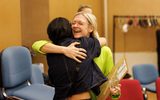 Two people hugging in a rehearsal room.