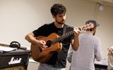 A young man playing the guitar.