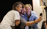 Three people taking a selfie. They are leaning in together and smiling