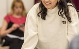 Maya Dhokia in rehearsals for East is East. She is wearing a white sweatshirt and colourful bandana in her hair.