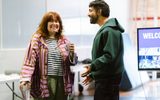 A man and woman standing together and laughing at the meet and greet for Othello