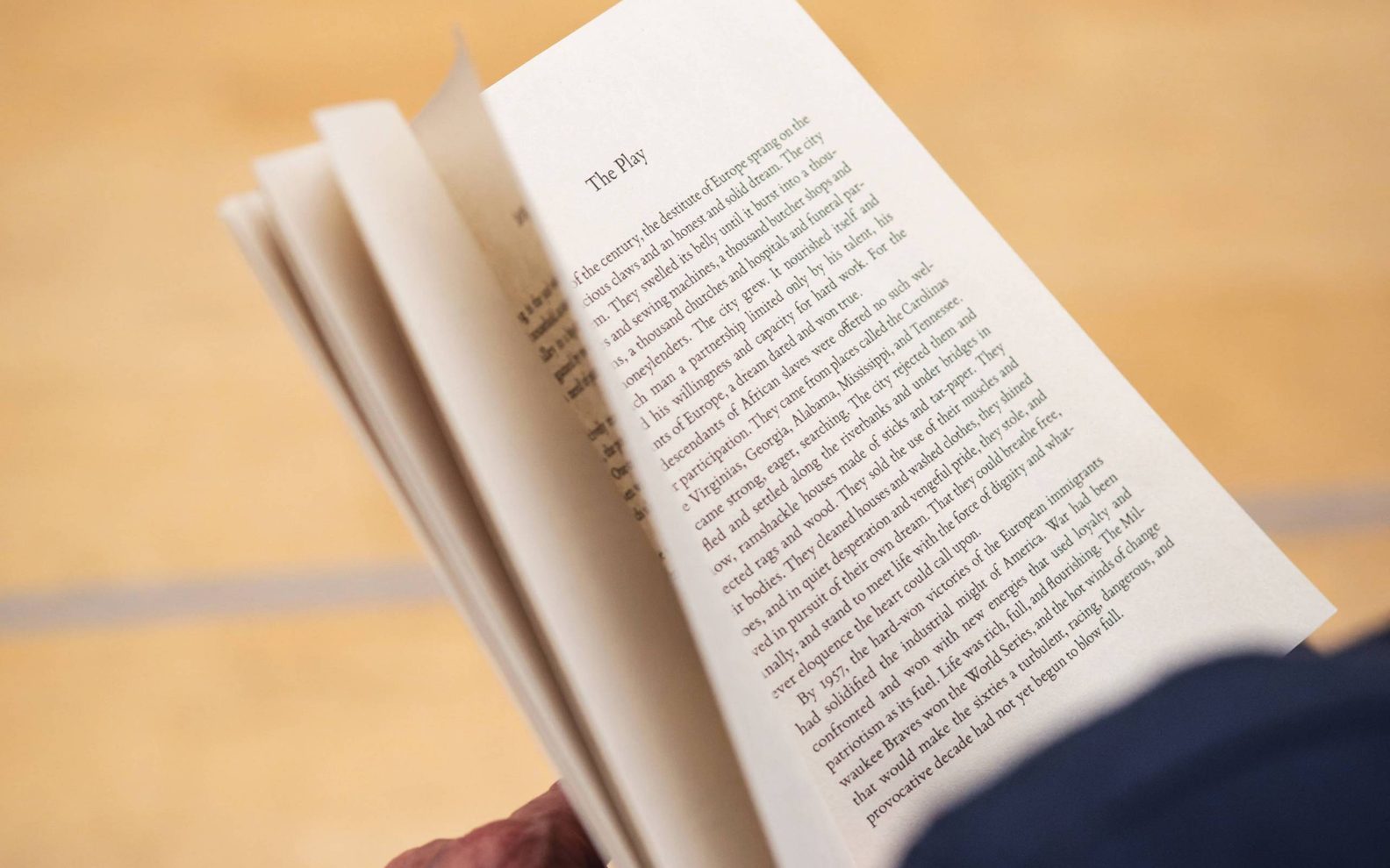 A play reading session. An open book being held in a person's hands.